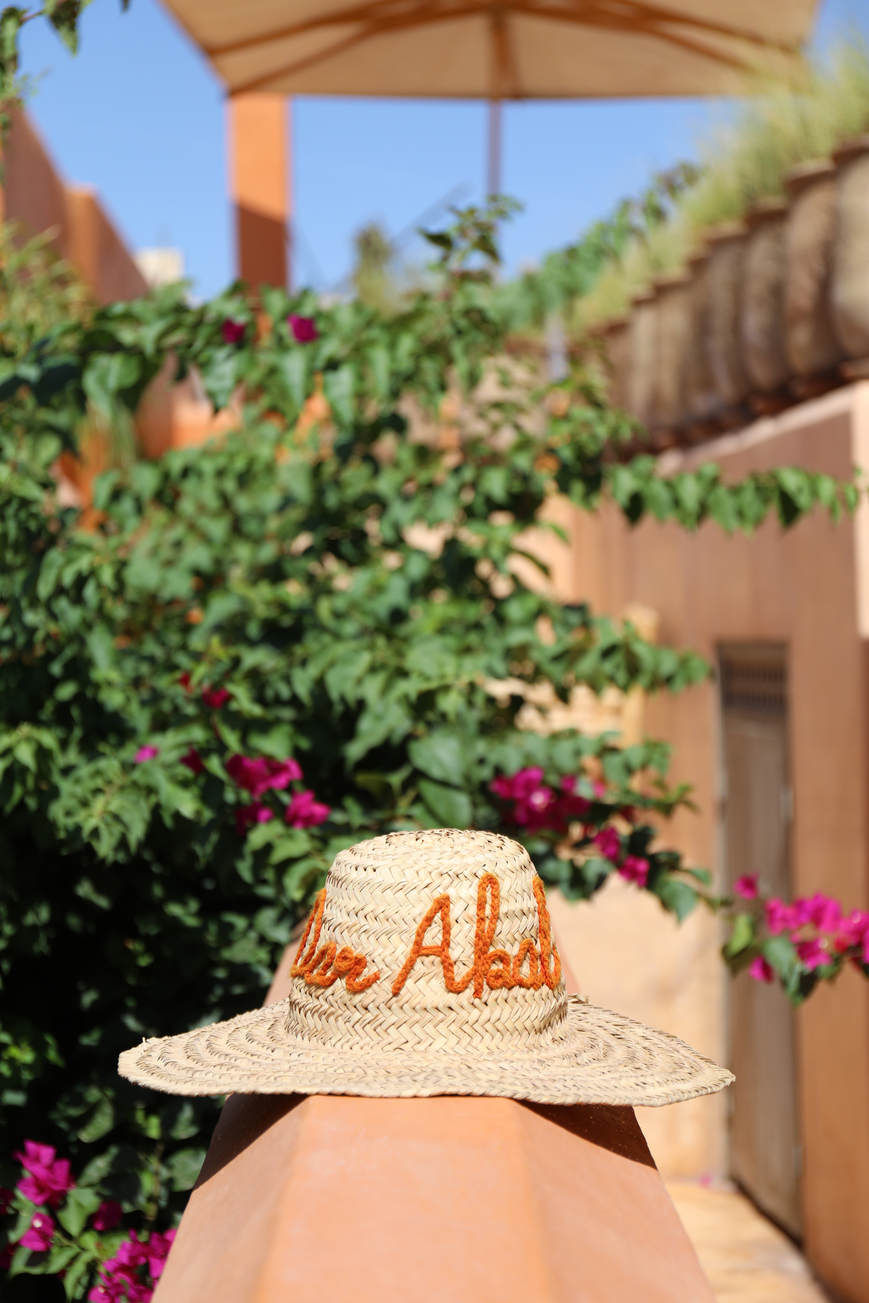 A woven Dar Akal hat among bougainvillea on the rooftop terrace