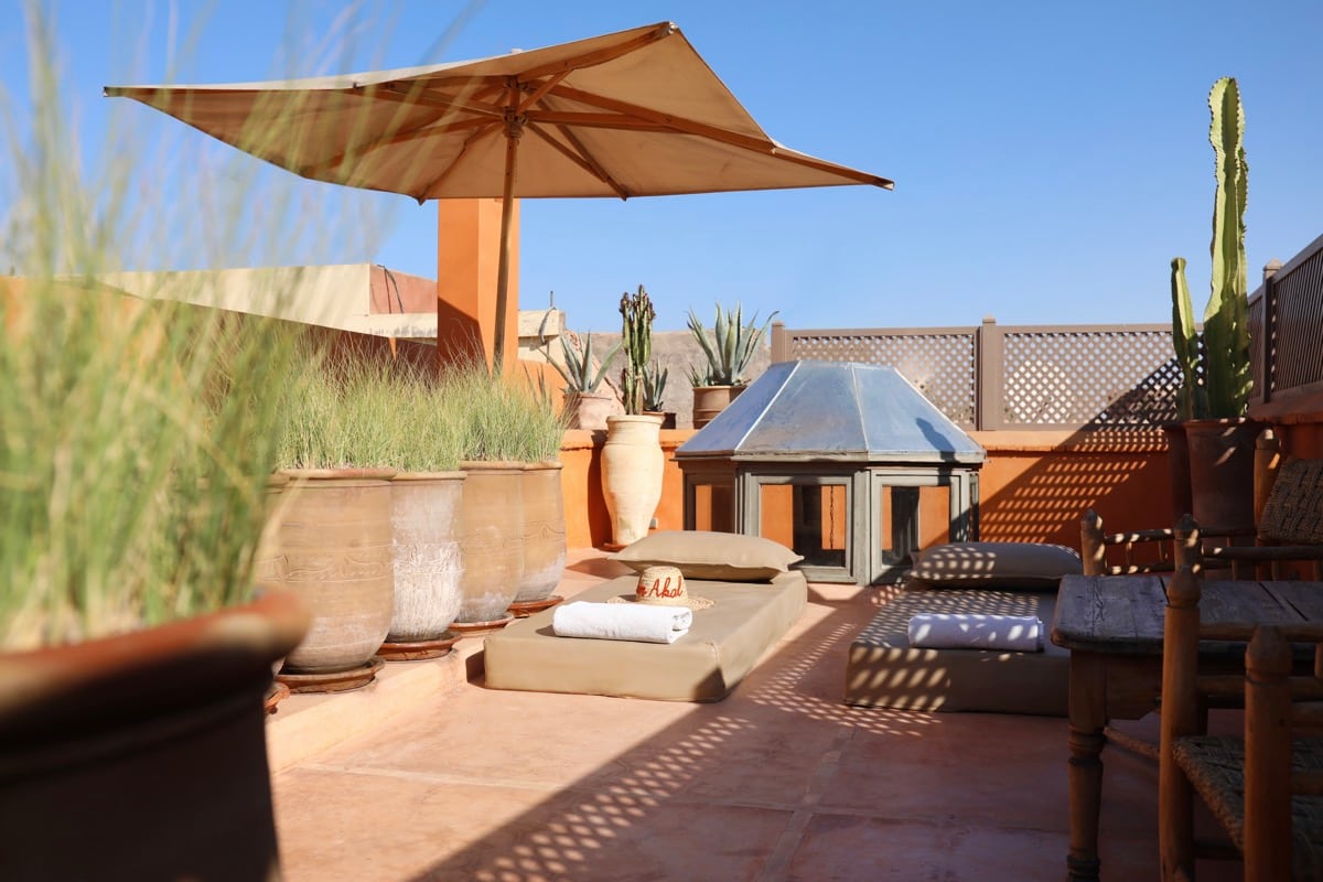 Sun loungers, parasol and cacti on Dar Akal's rooftop terrace
