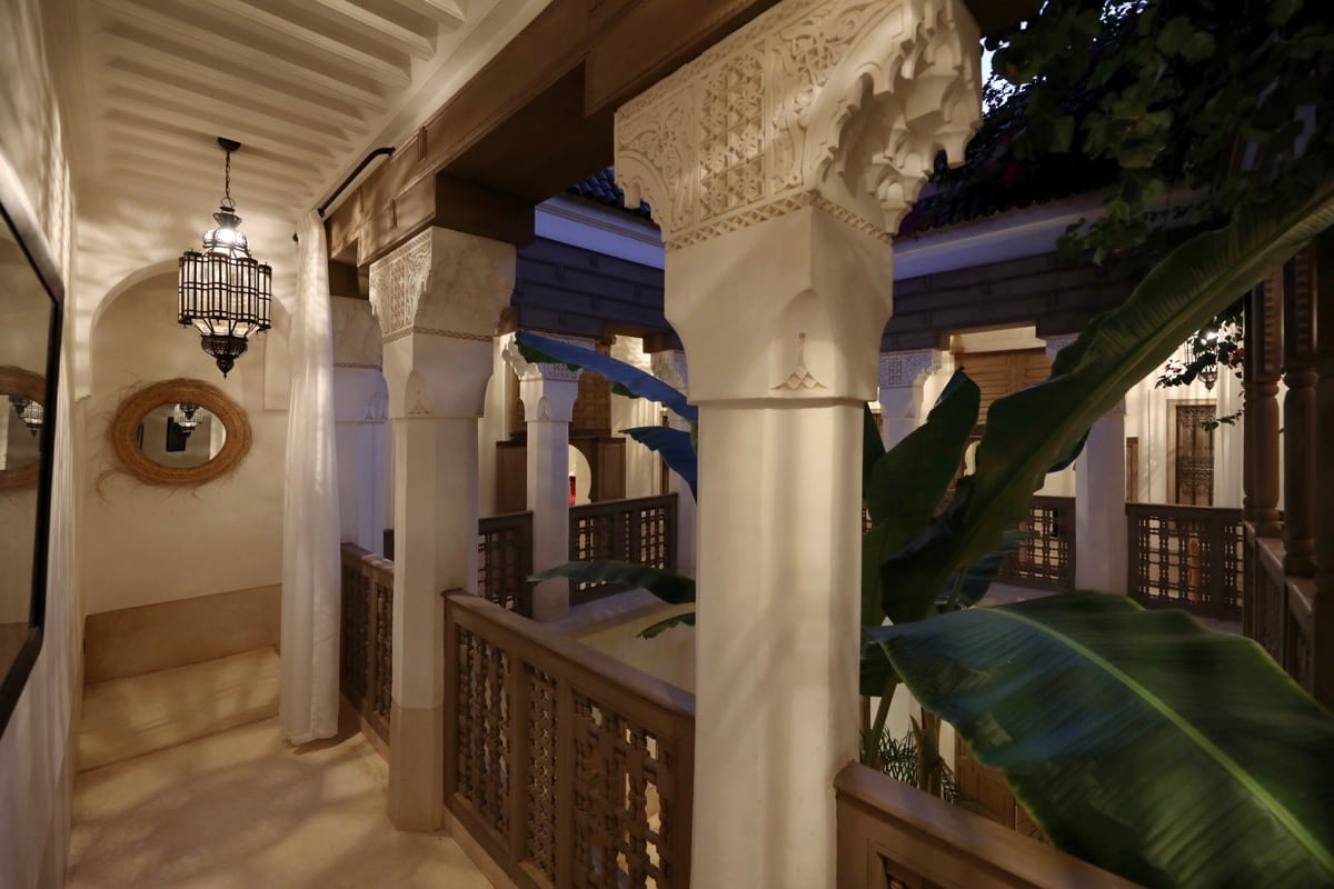 A carved upper gallery overlooking the courtyard at dusk