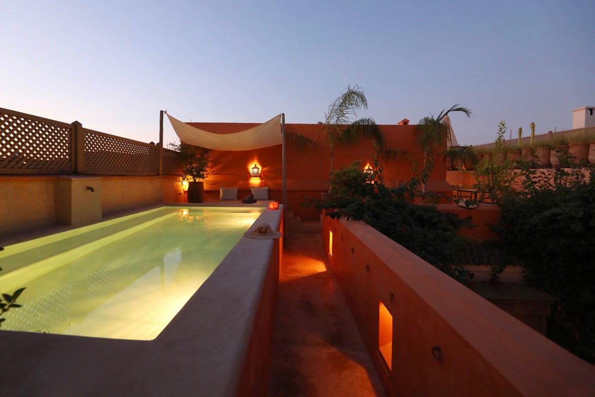 The rooftop pool glowing at blue hour