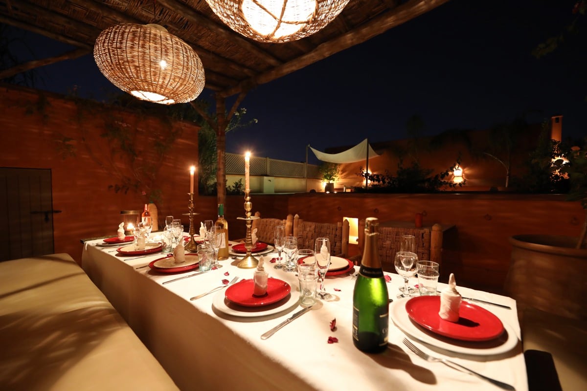 A long candlelit dinner table on Dar Akal's rooftop at night
