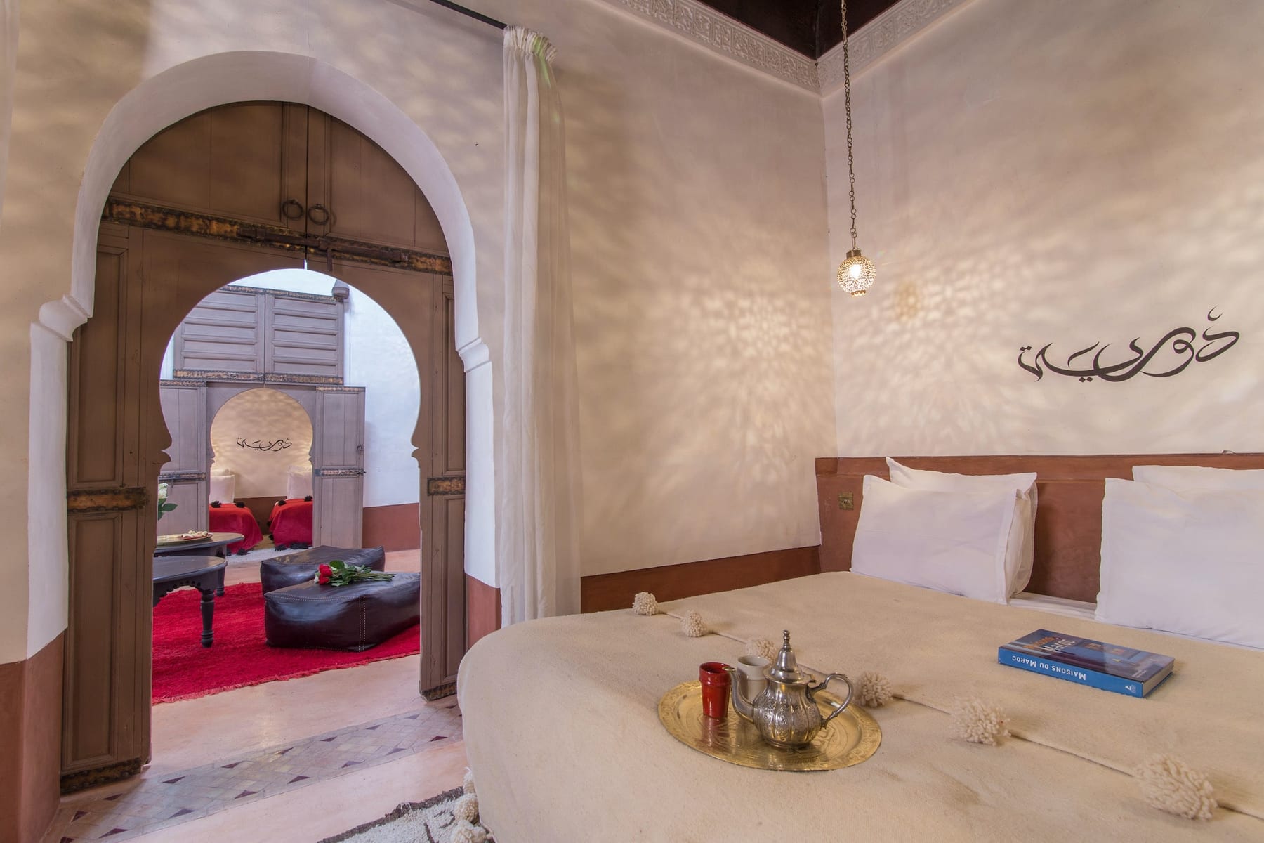 A bedroom in the Douiria Suite opening through its carved arches